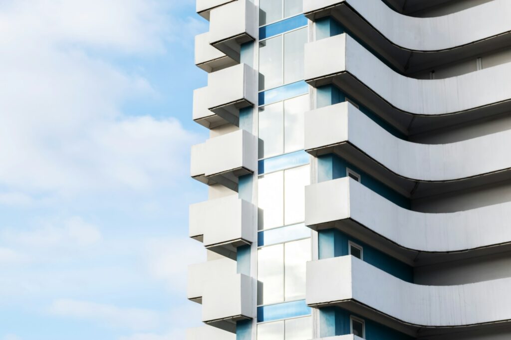 Modern building facade with balconies and glass windows against the sky.